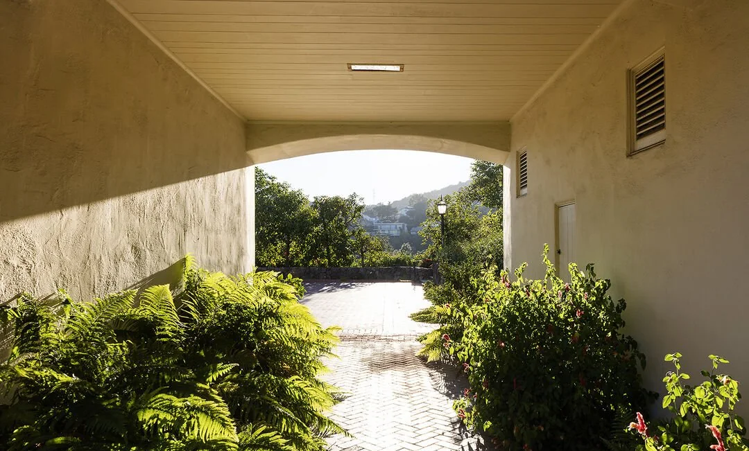 Covered loggia opening onto a brick path and canyon view