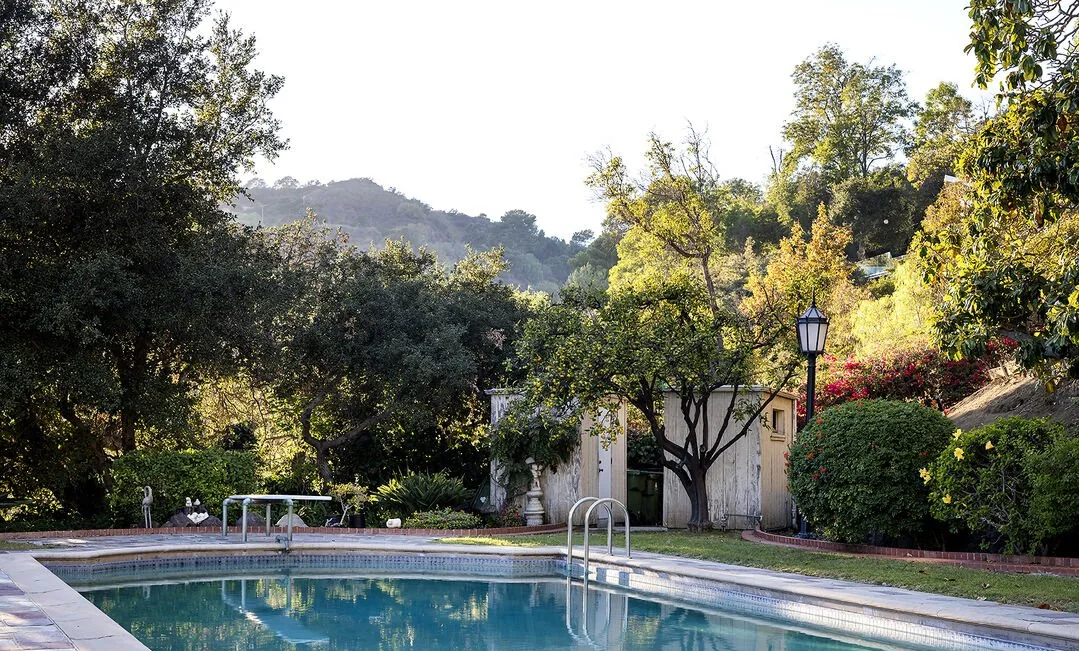 Pool framed by oaks with a canyon view
